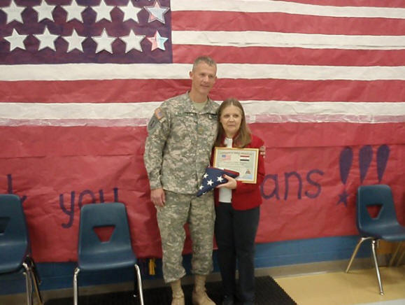 Major Tim Shubert of the 278th Armored Calvary Regiment, left, presents Loudon Elementary School Principal Kim Greenway with a flag that flew in Iraq during his last deployment. The students at the school have written to Shubert, a Loudon resident, during both of his deployments to Iraq.