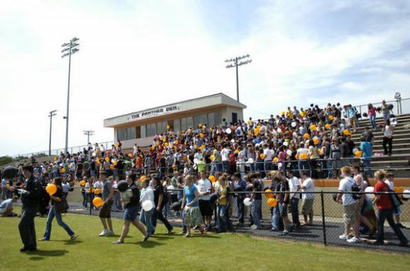 Students take to the field to release balloons during a ...